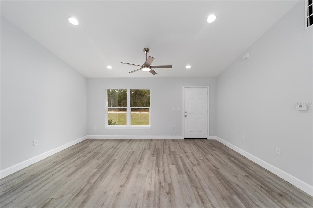 6832 Southwest 153rd Pl Road Ocala, FL 34473 - Photo 9 of 31 wooden floor in an empty room with a window
