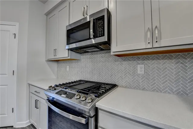 a kitchen with microwave cabinets and stove top oven