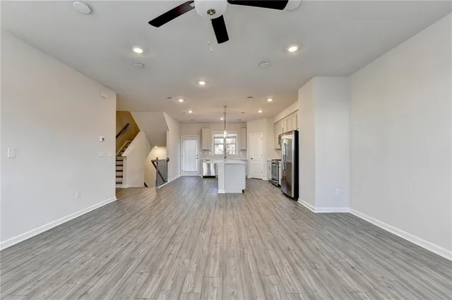 a view of a living room with wooden floor and a ceiling fan