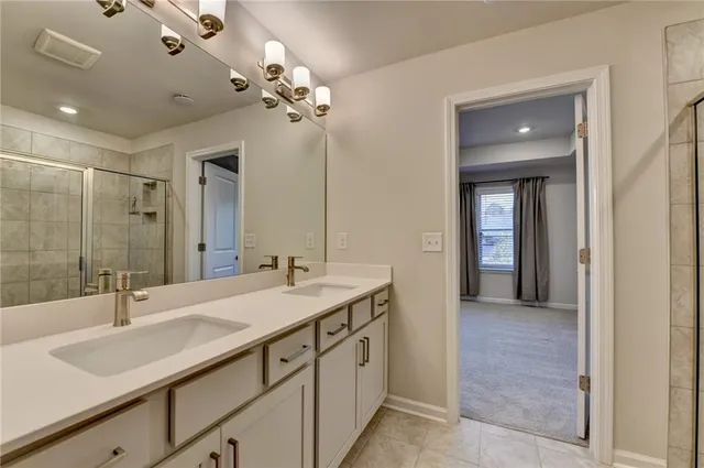 a spacious bathroom with a double vanity sink a large mirror and shower