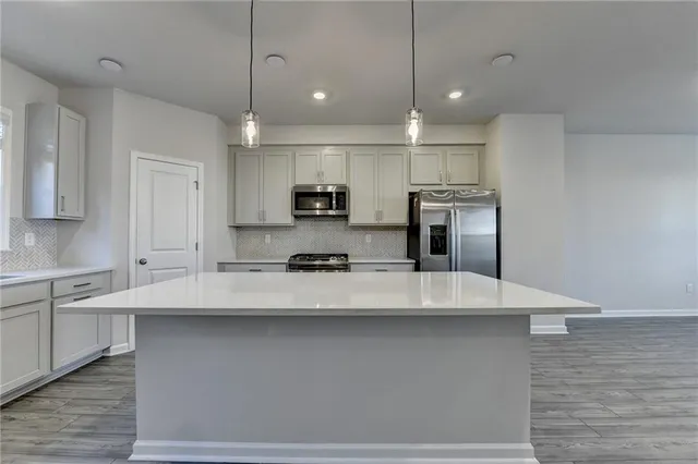 a large kitchen with kitchen island a sink stainless steel appliances and cabinets
