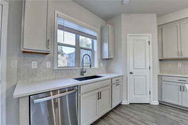 a kitchen with stainless steel appliances granite countertop a sink and a window