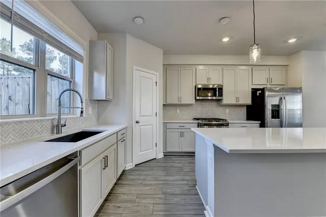a kitchen with stainless steel appliances granite countertop a sink stove and refrigerator