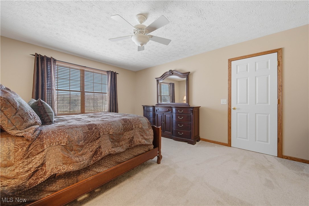 2132 Summerchase Road Northeast Canton, OH 44721 - Photo 24 of 49 Bedroom with a textured ceiling, light colored carpet, and a ceiling fan