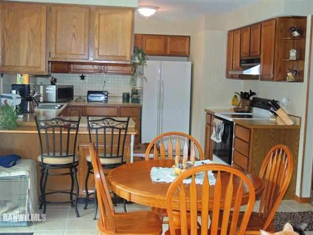 4702 Thorne Road Marengo, IL 60152 - Photo 3 of 12 a kitchen with stainless steel appliances a table chairs and a refrigerator