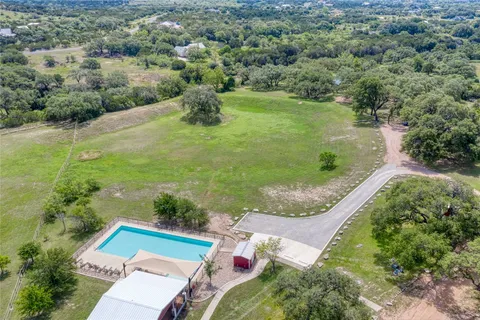 an aerial view of a house with a yard and lake view