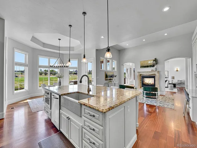 a open kitchen with granite countertop a stove refrigerator and wooden floor