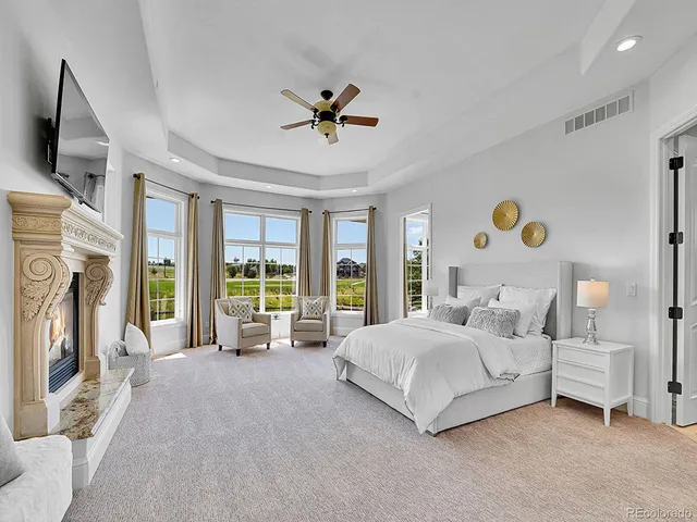 a spacious bedroom with a bed couch and a flat tv screen