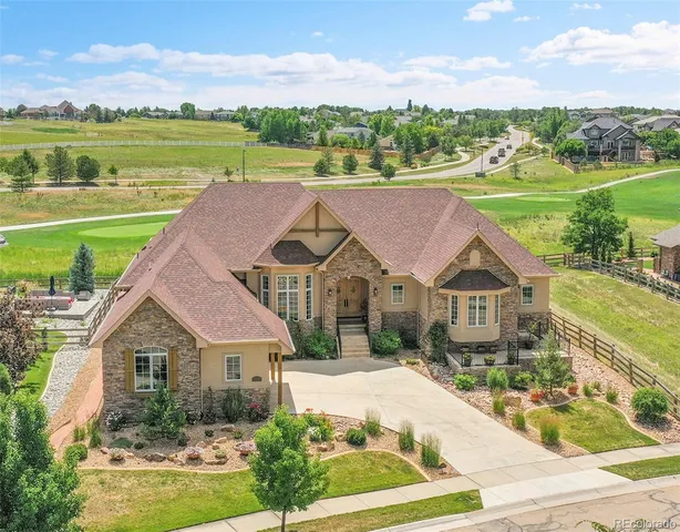 a aerial view of a house with a big yard and potted plants