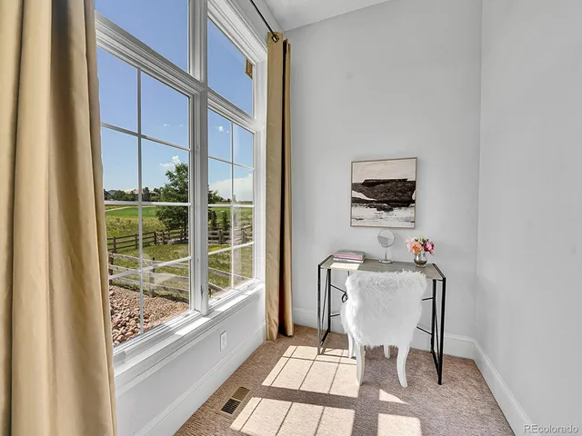 a view of a room with a window and chairs