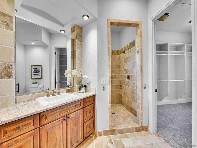 a bathroom with a granite countertop sink mirror and shower