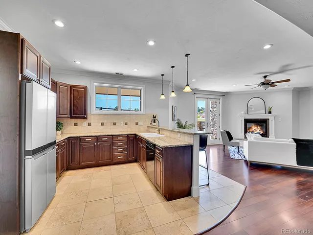 a large kitchen with stainless steel appliances kitchen island granite countertop a large stove a sink dishwasher and a refrigerator with wooden floor