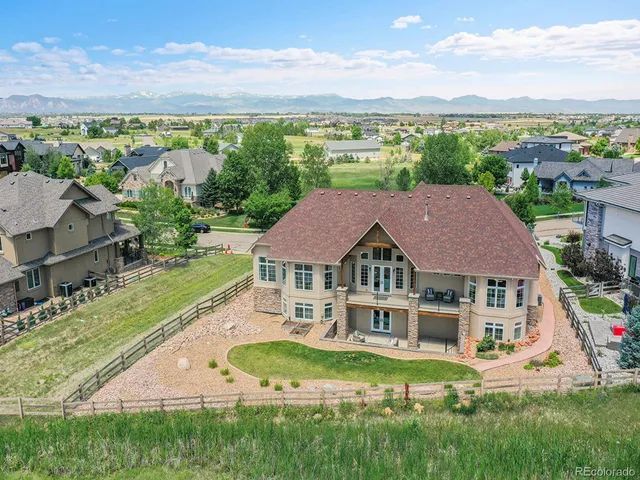 a aerial view of a house with a big yard and large trees