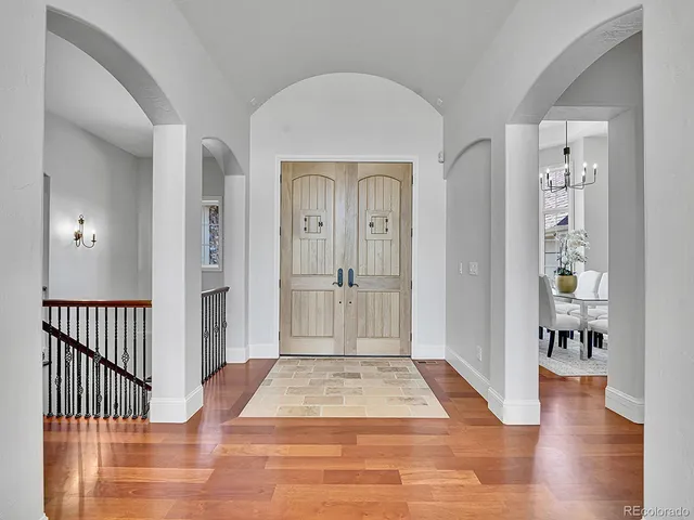 a view of a hallway with wooden floor and a living room