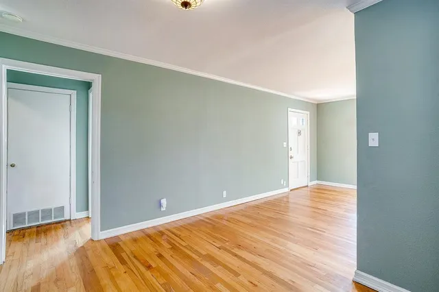 a view of an empty room with wooden floor