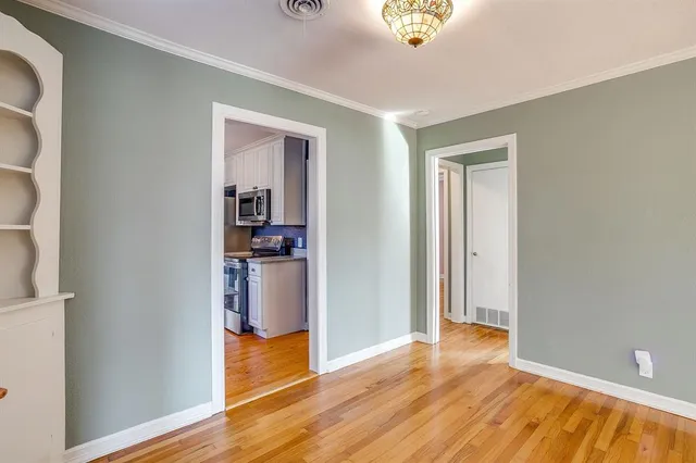 a view of a room with wooden floor and a window