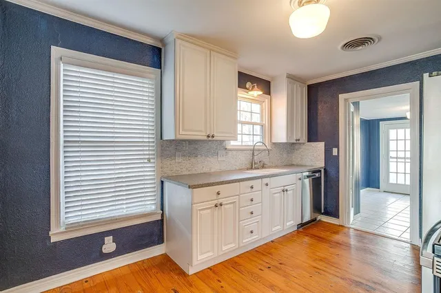 a kitchen with granite countertop a sink cabinets and a large window