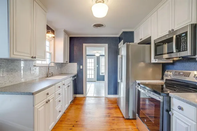 a kitchen with stainless steel appliances granite countertop a stove a sink and a refrigerator