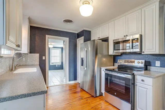 a kitchen with stainless steel appliances granite countertop a refrigerator sink and stove