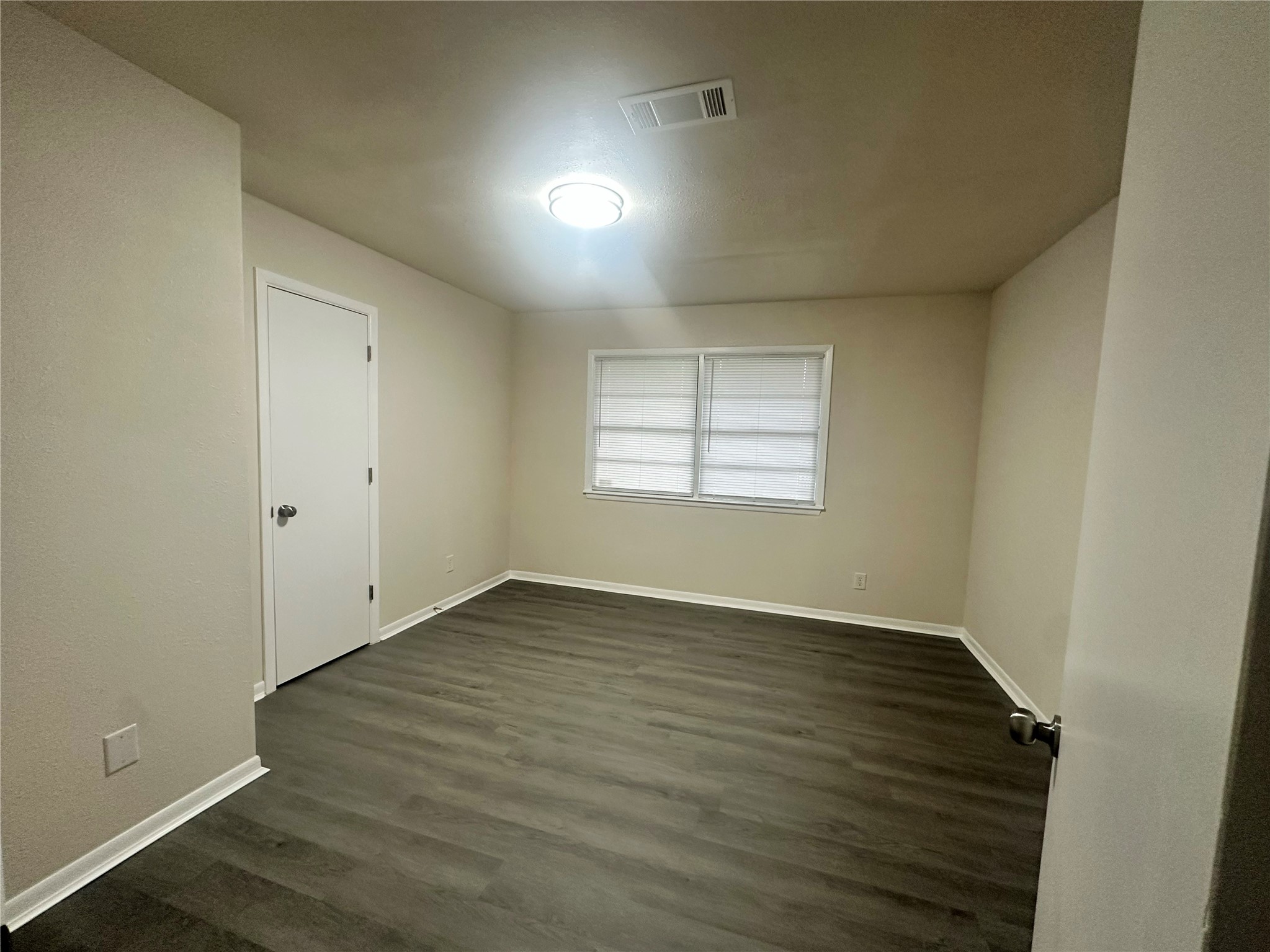 130 Bay Ridge Drive Baytown, TX 77523 - Photo 12 of 20 This is a bright room with neutral walls and flooring. It features a window with blinds and a ceiling light, creating a clean, modern look.