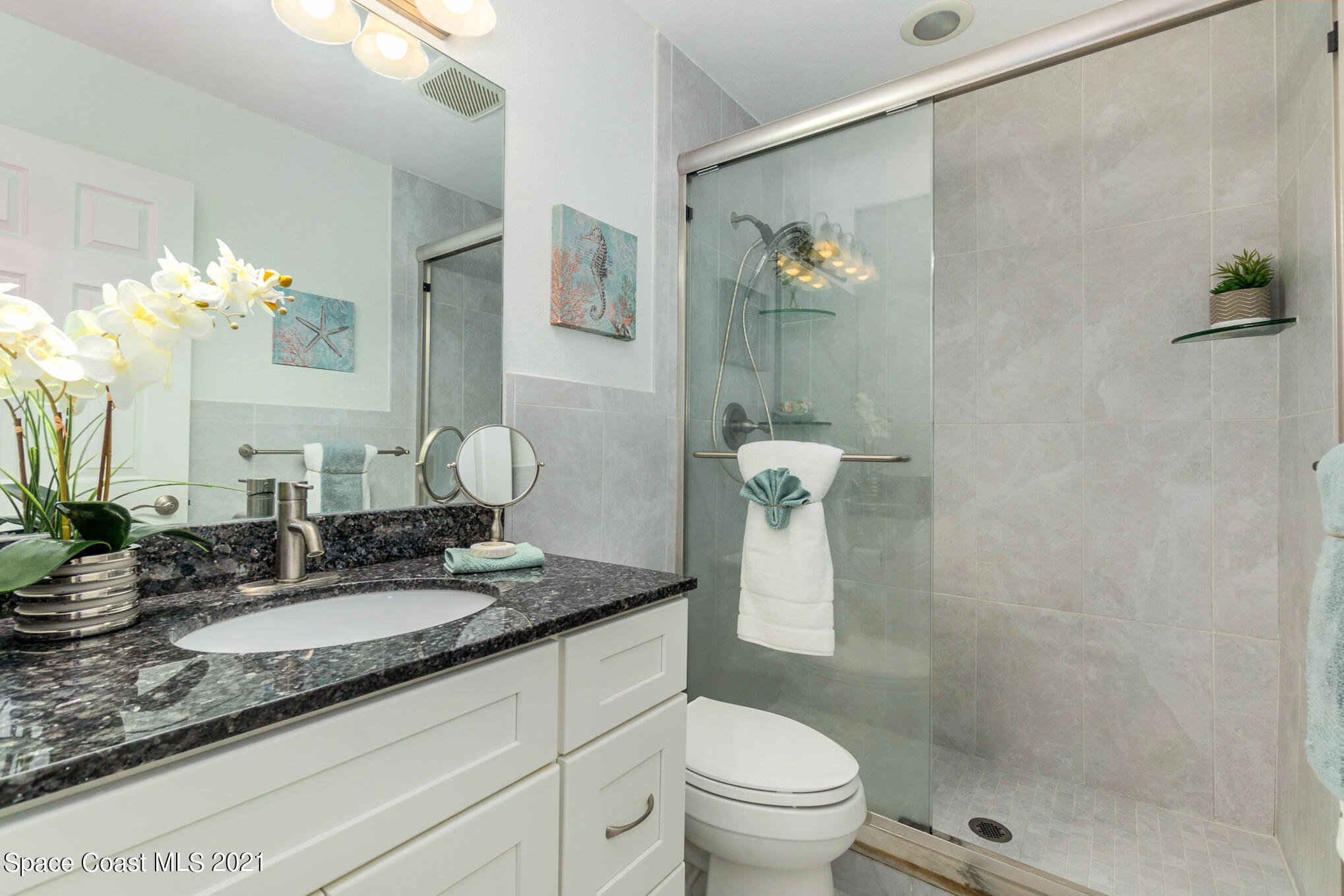 1805 Evers Road Melbourne, FL 32934 - Photo 12 of 29 a bathroom with a granite countertop sink a toilet and a mirror