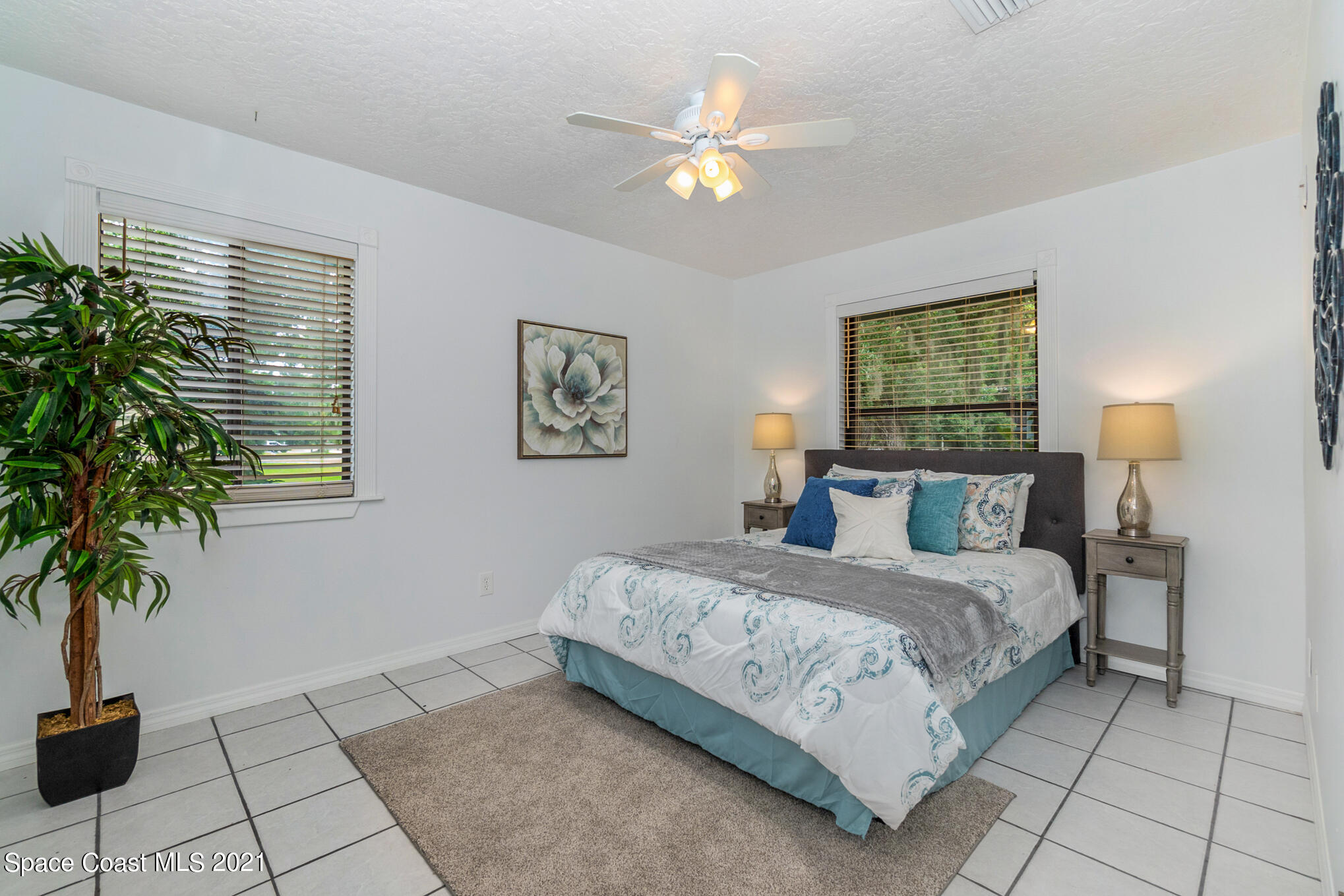 1805 Evers Road Melbourne, FL 32934 - Photo 13 of 29 a bedroom with a large bed and a potted plant