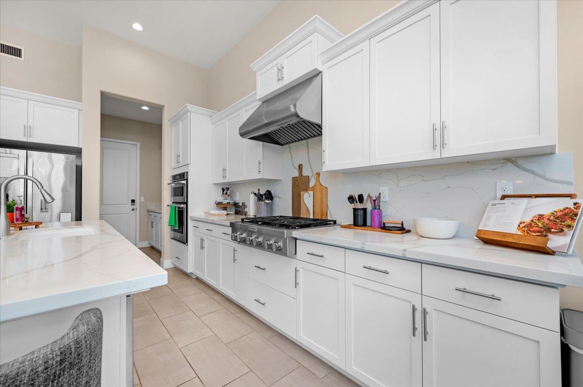 1003 Highland Road Madera, CA 93636 - Photo 20 of 73 a kitchen with stainless steel appliances white cabinets and a sink