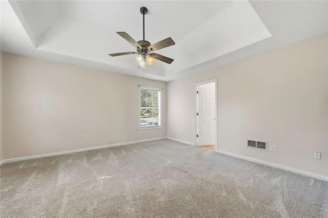 an empty room with a ceiling fan and a window