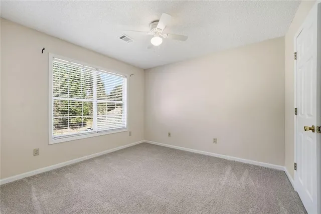 an empty room with a ceiling fan and a window