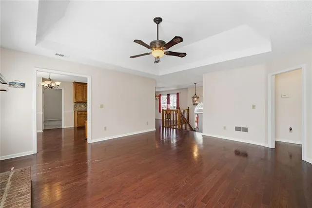a view of an empty room with wooden floor fireplace and a window
