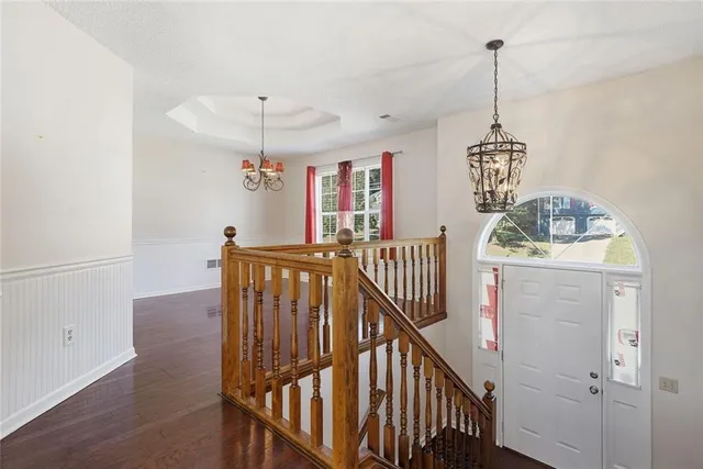 an empty room with wooden floor fireplace and fan