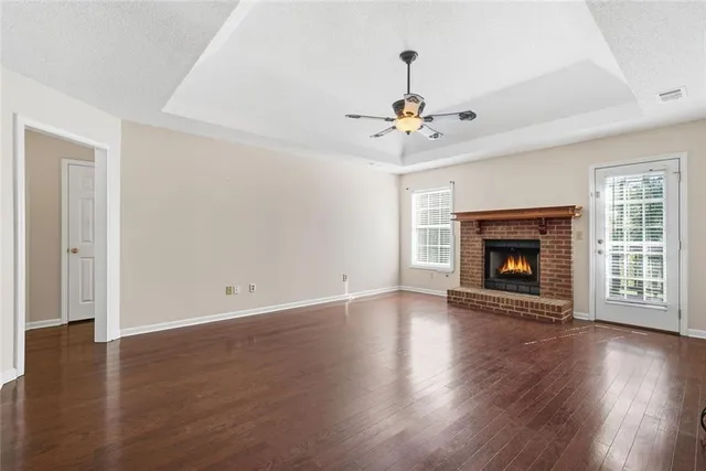 a kitchen with stainless steel appliances granite countertop a stove a refrigerator a sink dishwasher a dining table and chairs with wooden floor