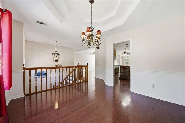 a kitchen with stainless steel appliances granite countertop a stove a refrigerator a sink dishwasher a dining table and chairs with wooden floor