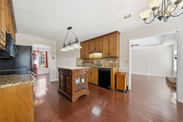 a kitchen with stainless steel appliances granite countertop a stove refrigerator sink and cabinets