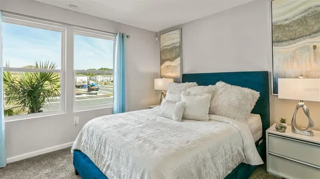 a large bed sitting in a bedroom next to a window