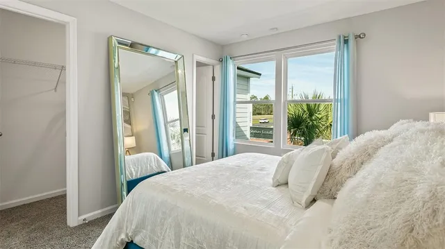 a large bed sitting in a bedroom next to a window