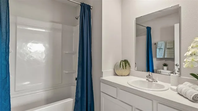 a bathroom with a granite countertop sink a toilet and shower