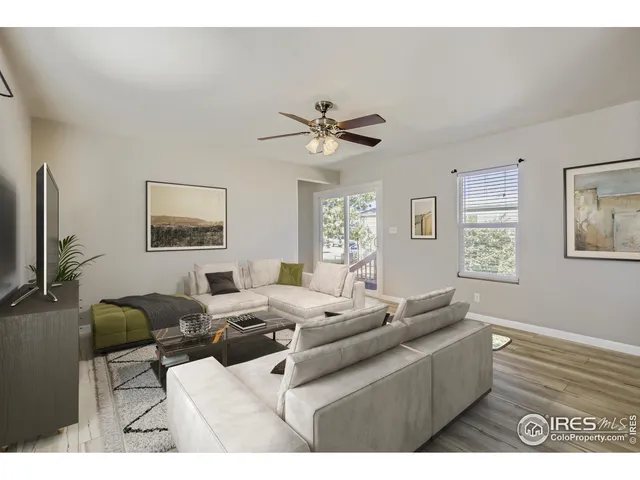 a living room with furniture a window and a flat screen tv
