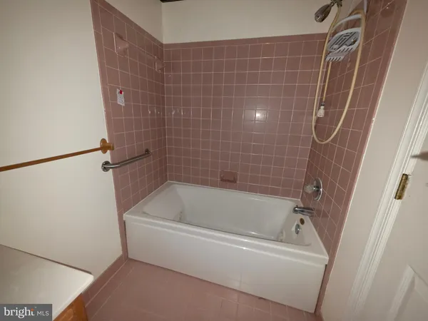 a white bath tub sitting next to a white sink and vanity