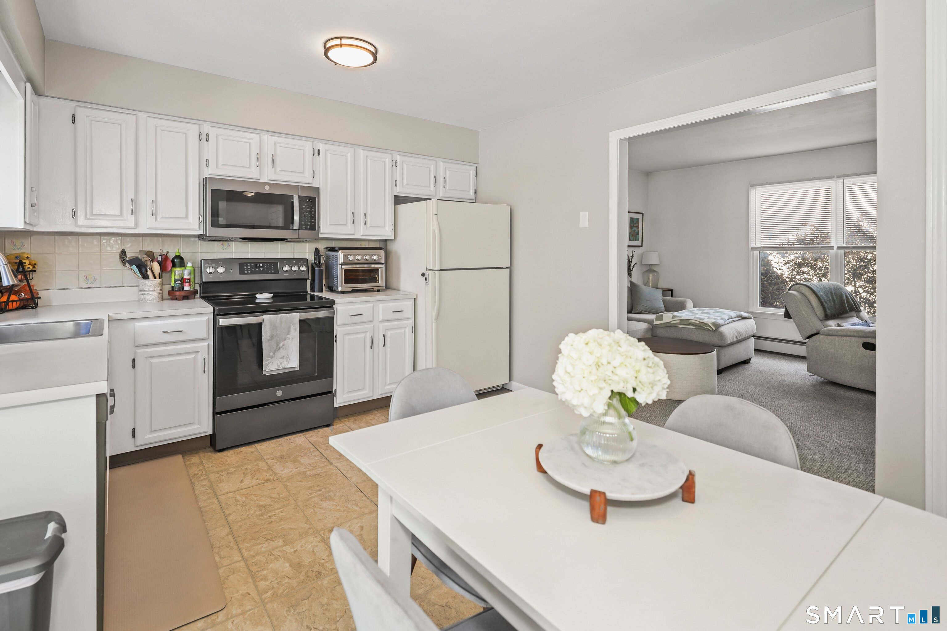 29 Toas Street, Unit 29 Shelton, CT 06484 - Photo 11 of 31 a kitchen with stainless steel appliances a white table and chairs