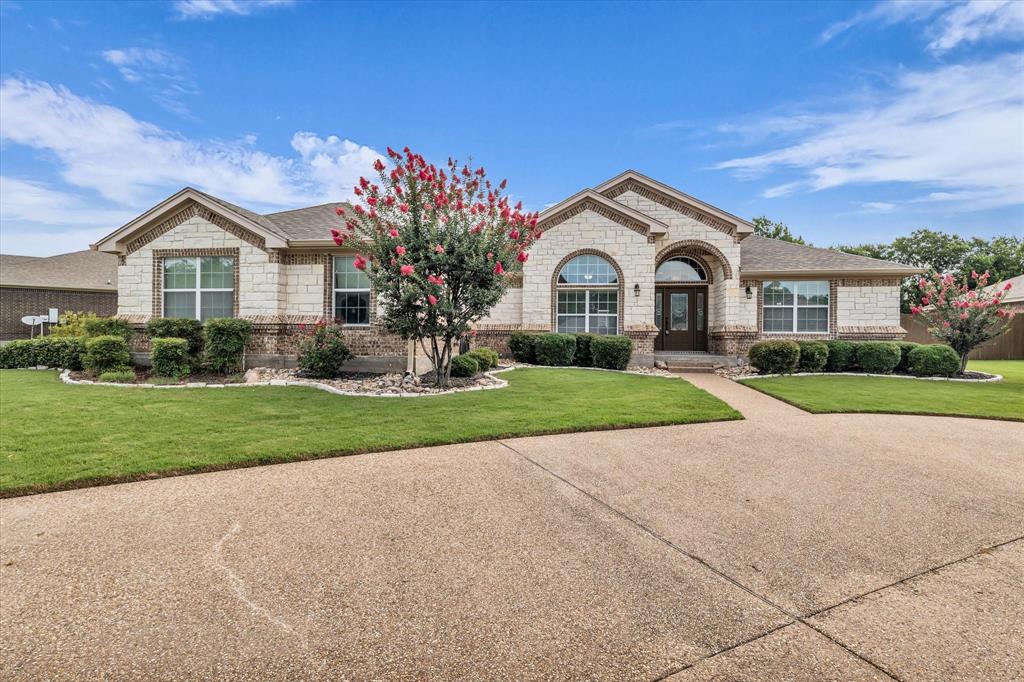 910 Springdale Lane Lorena, TX 76655 - Photo 2 of 39 Stone and brick facade with an arched entry and a dark wood front door