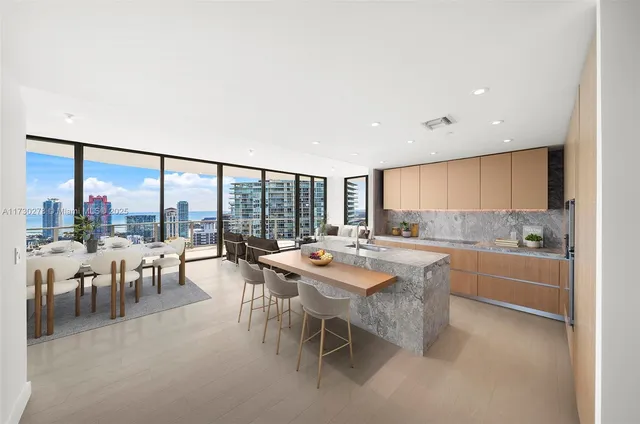 a room with lots of tables a large window and chairs