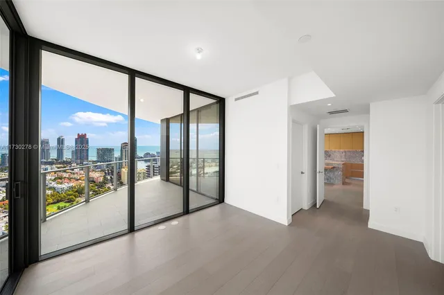 a view of an empty room with windows with view of balcony