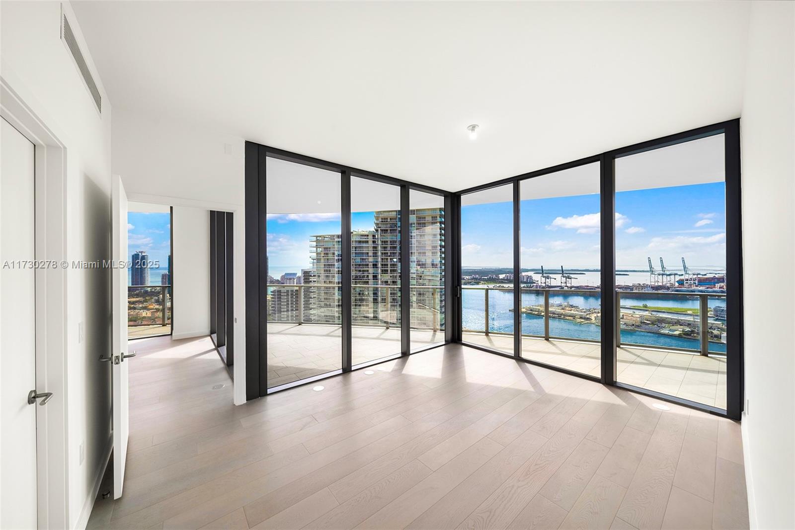 500 Alton Road, Unit 3101 Miami Beach, FL 33139 - Photo 17 of 53 a view of an empty room with wooden floor and a floor to ceiling window