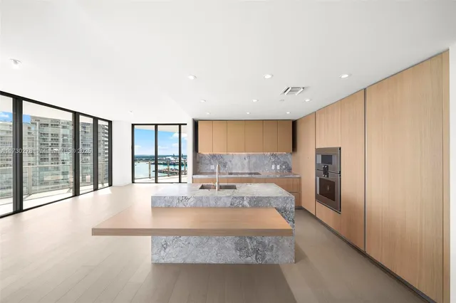 a large white kitchen with a large window