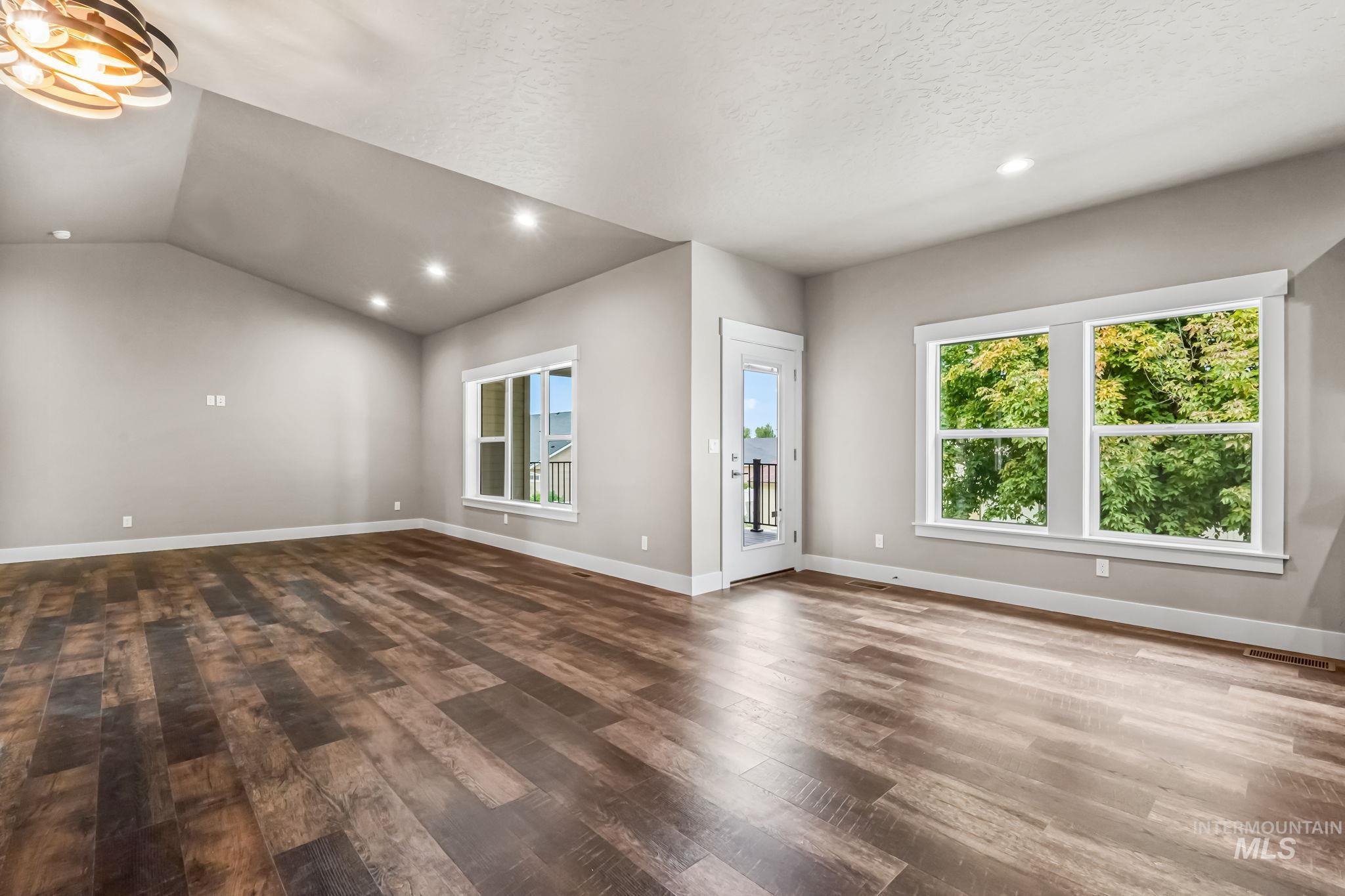 2755 Cypress Point Payette, ID 83661 - Photo 19 of 28 Unfurnished living room featuring vaulted ceiling, recessed lighting, wood finished floors, and a textured ceiling