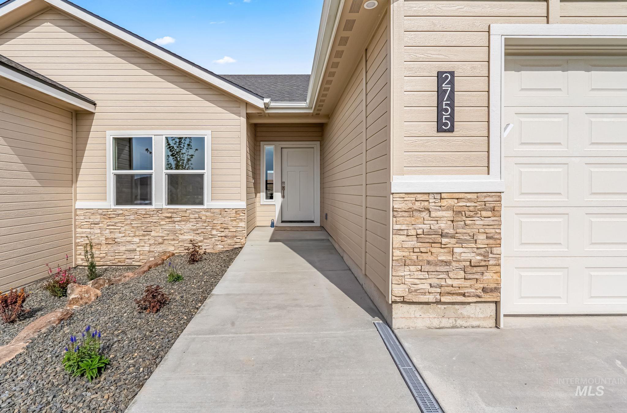 2755 Cypress Point Payette, ID 83661 - Photo 2 of 28 View of exterior entry featuring stone siding, roof with shingles, and a garage