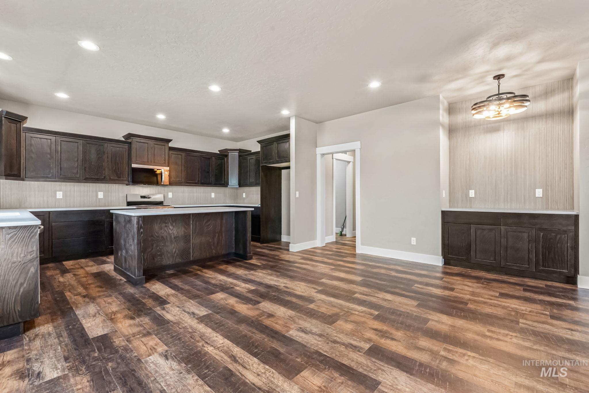 2755 Cypress Point Payette, ID 83661 - Photo 8 of 28 Kitchen featuring a center island, dark brown cabinets, light countertops, decorative backsplash, and recessed lighting