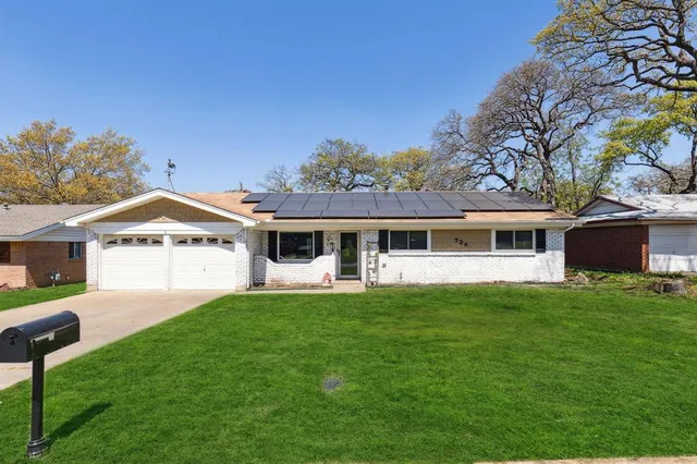 a front view of a house with a garden and yard
