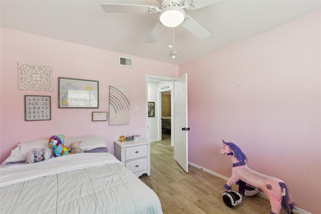 724 Edgehill Drive Hurst, TX 76053 - Photo 19 of 27 a bedroom with a bed and a chandelier